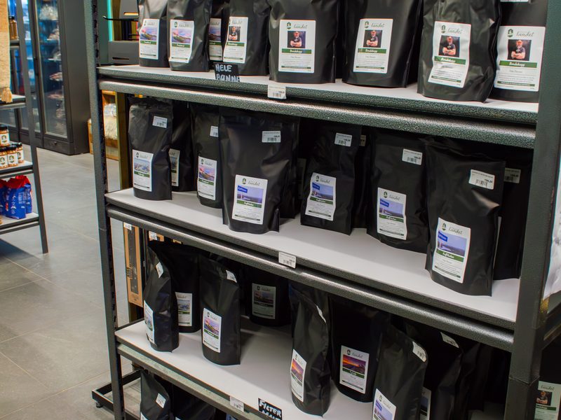 Hyller med egenmerkede kaffeposer i gårdsutsalget